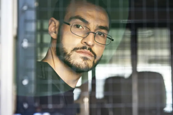 Ben Field à l'arrière d'un fourgon de police regardant par la fenêtre arrière