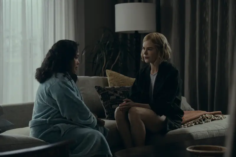Margaret est assise sur un canapé et discute avec quelqu'un en face d'elle.