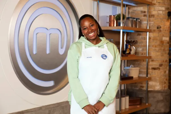 A cantora Jamelia participa do Celebrity Masterchef 2023, vestindo avental branco e moletom verde