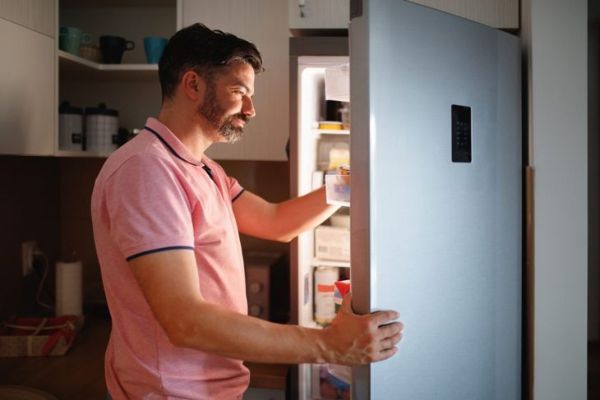 Homme sortant de la nourriture du réfrigérateur