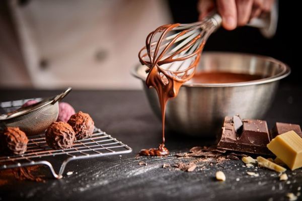 panadero con batidor para masa de pastel de chocolate