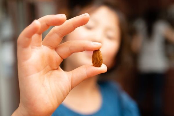 gadis kecil memegang satu almond