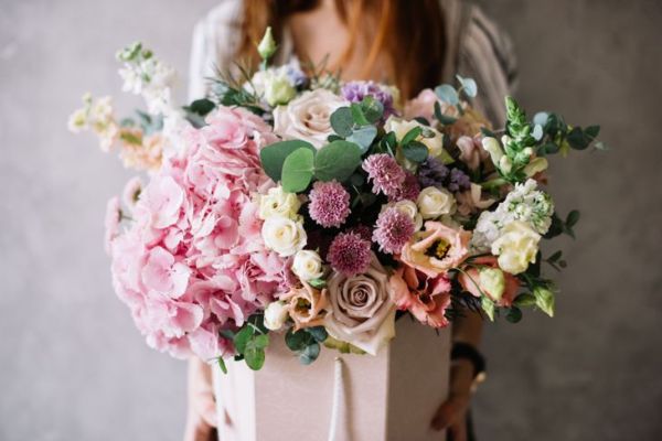 Très belle jeune femme tenant un beau bouquet de fleurs tendres d'hortensia frais