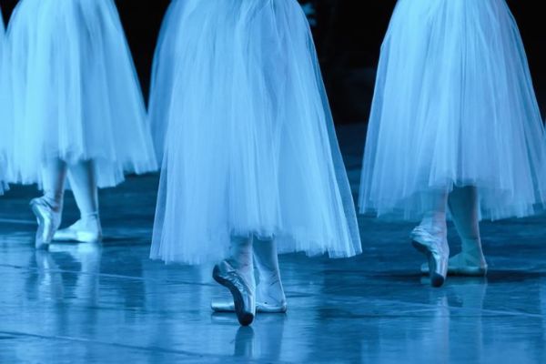 Gruppo di ballerine in tutù bianco di Chopin che ballano sincronizzate sul palco.