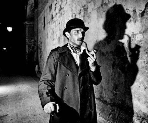 Immagine in bianco e nero di un detective che fuma la pipa