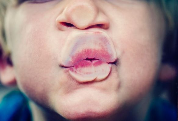 Petit garçon écrasant sa bouche contre le verre pour souffler un baiser