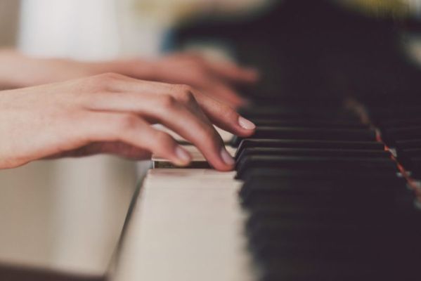 أصابع المرأة تلعب البيانو