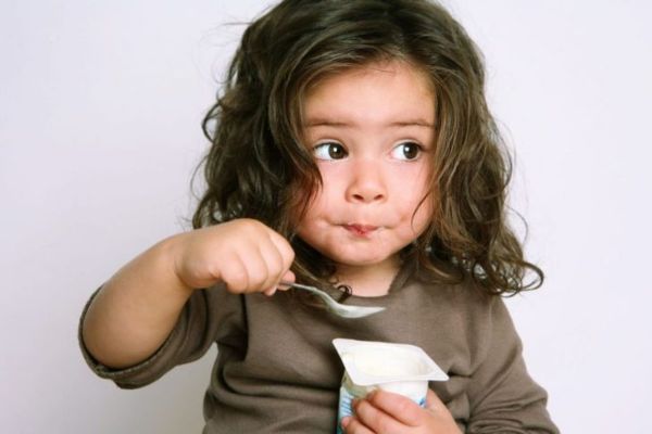 Bambina che mangia yogurt