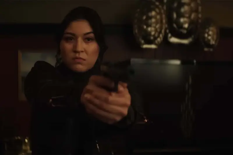Echo (Alaqua Cox) segura uma pistola apontada para alguém na sua frente
